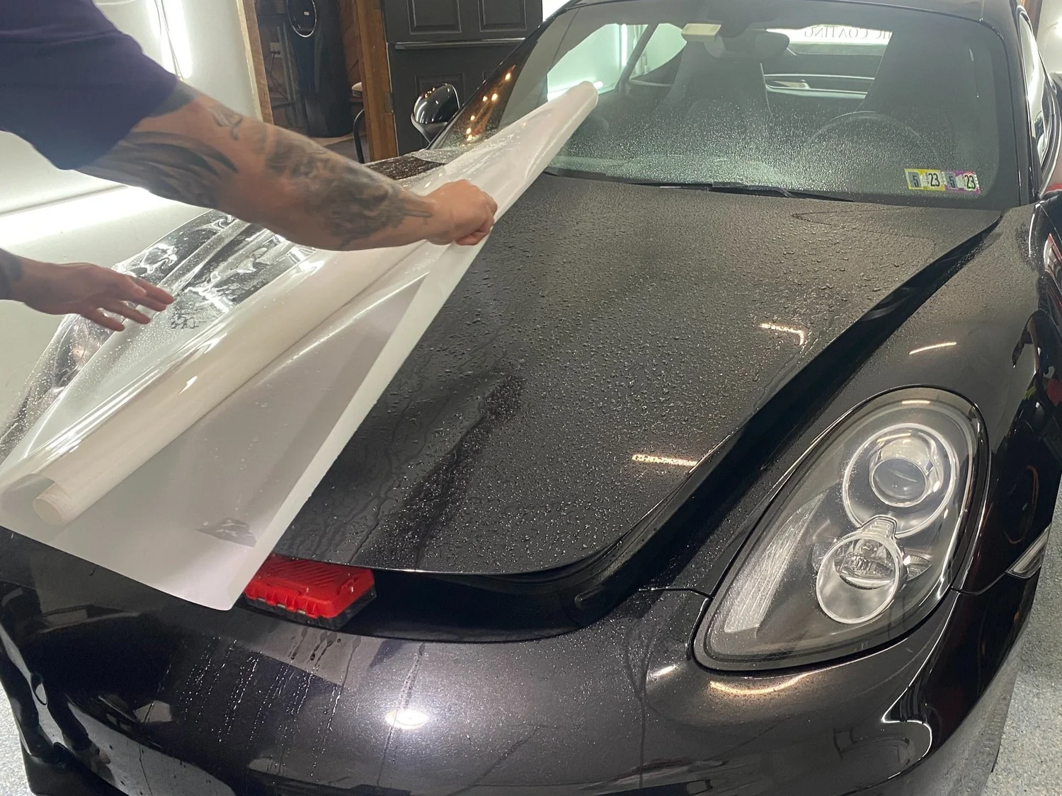 Paint protection film being applied to a Porsche